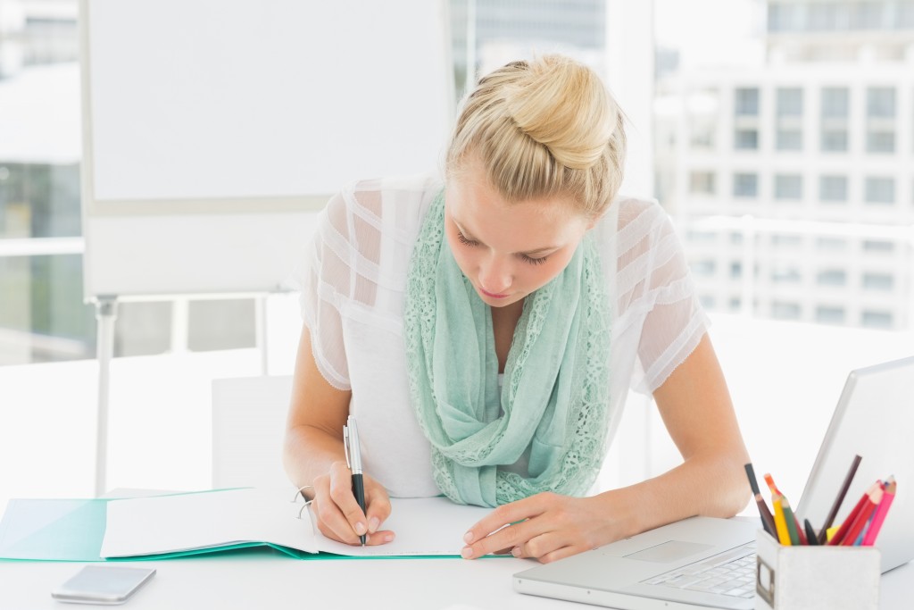 Casual young woman writing notes