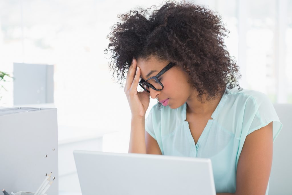 goal setting focus tired from afternoon slump Stressed hipster businesswoman working on laptop