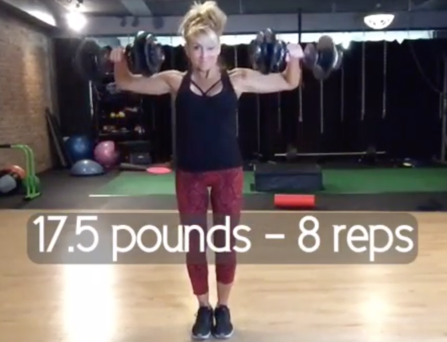 Chalene Johnson standing in a gym holding two kettles