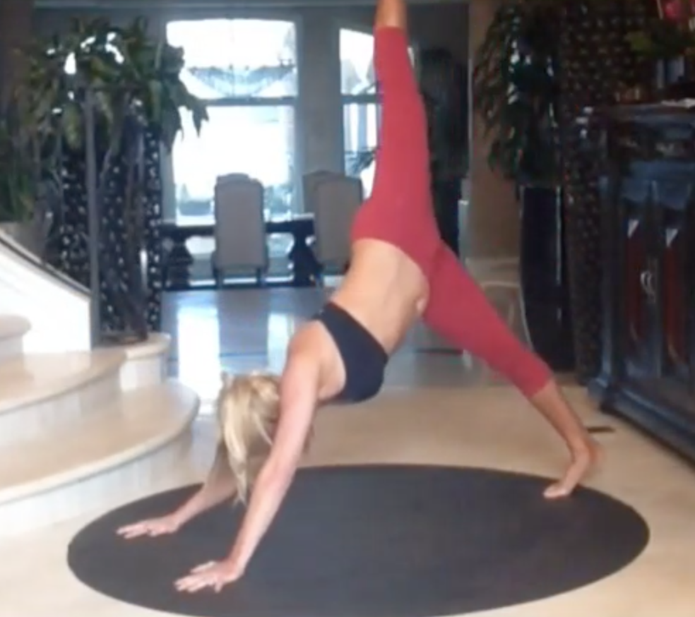 Chalene Johnson doing a handstand on a rug