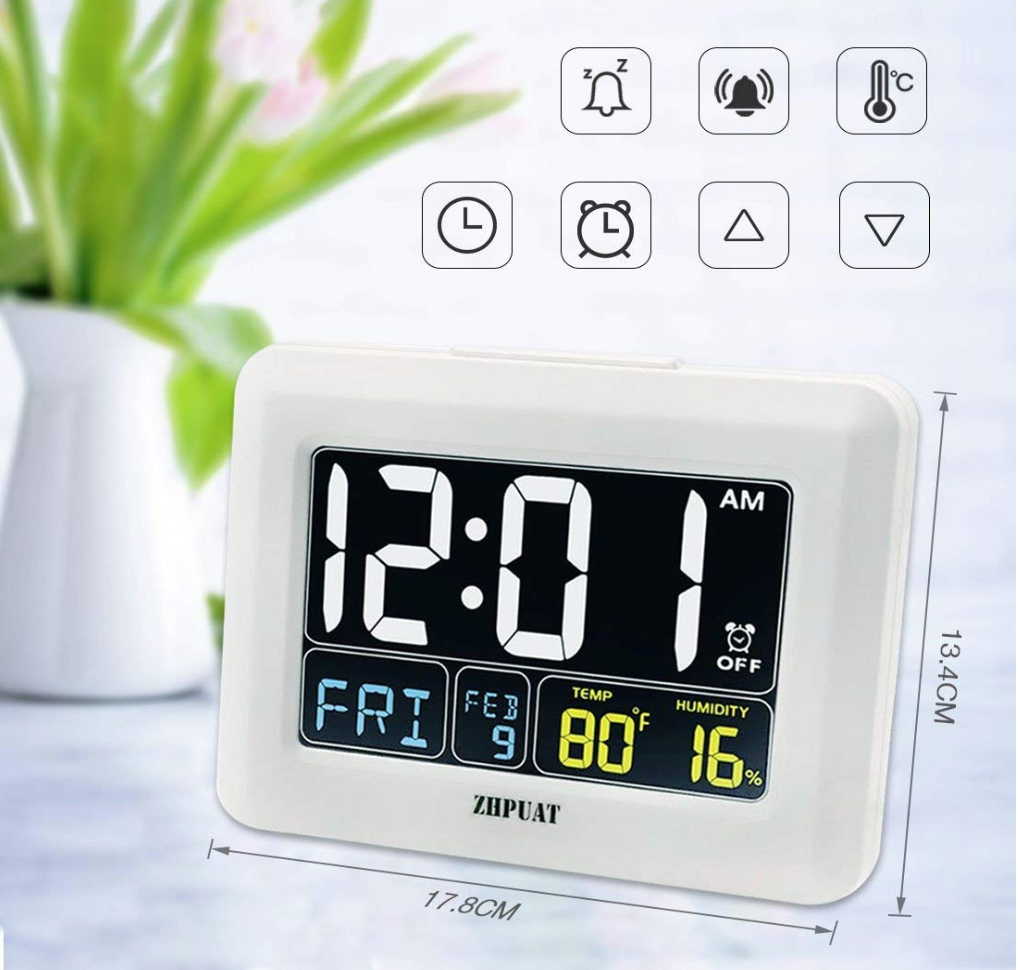 a white digital clock kept on top of a table